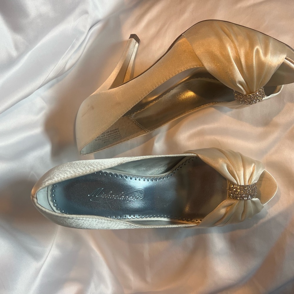Cream colored satin peep toe heels with rhinestones.